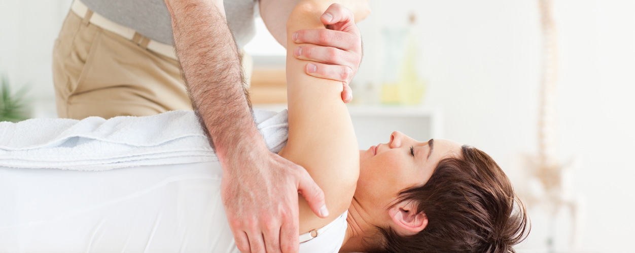 therapist working on patients shoulder