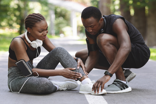 man checking injured woman's ankle